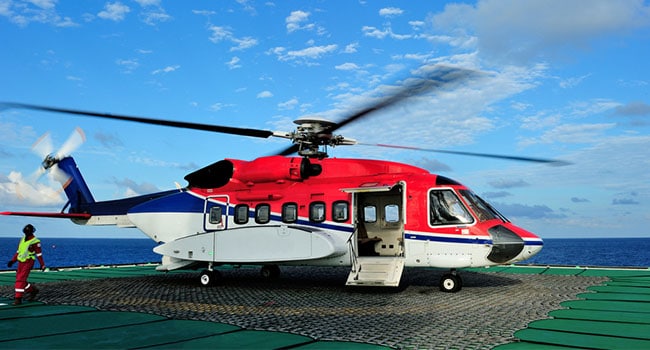 Red helicopter on a helipad awaiting takeoff